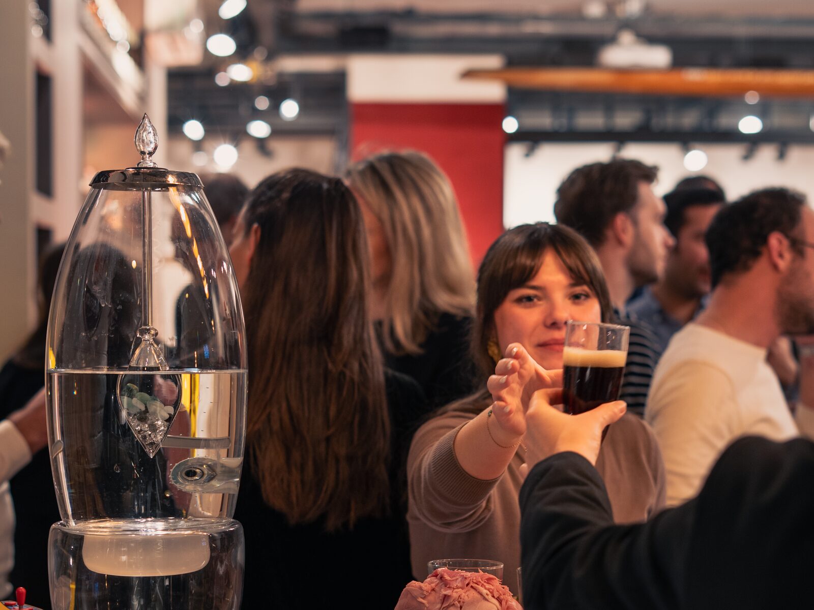 Soirée privatisée à La Fabrique Générale · invités verre à la main autour de la fontaine à eau cristalline, ambiance chaleureuse