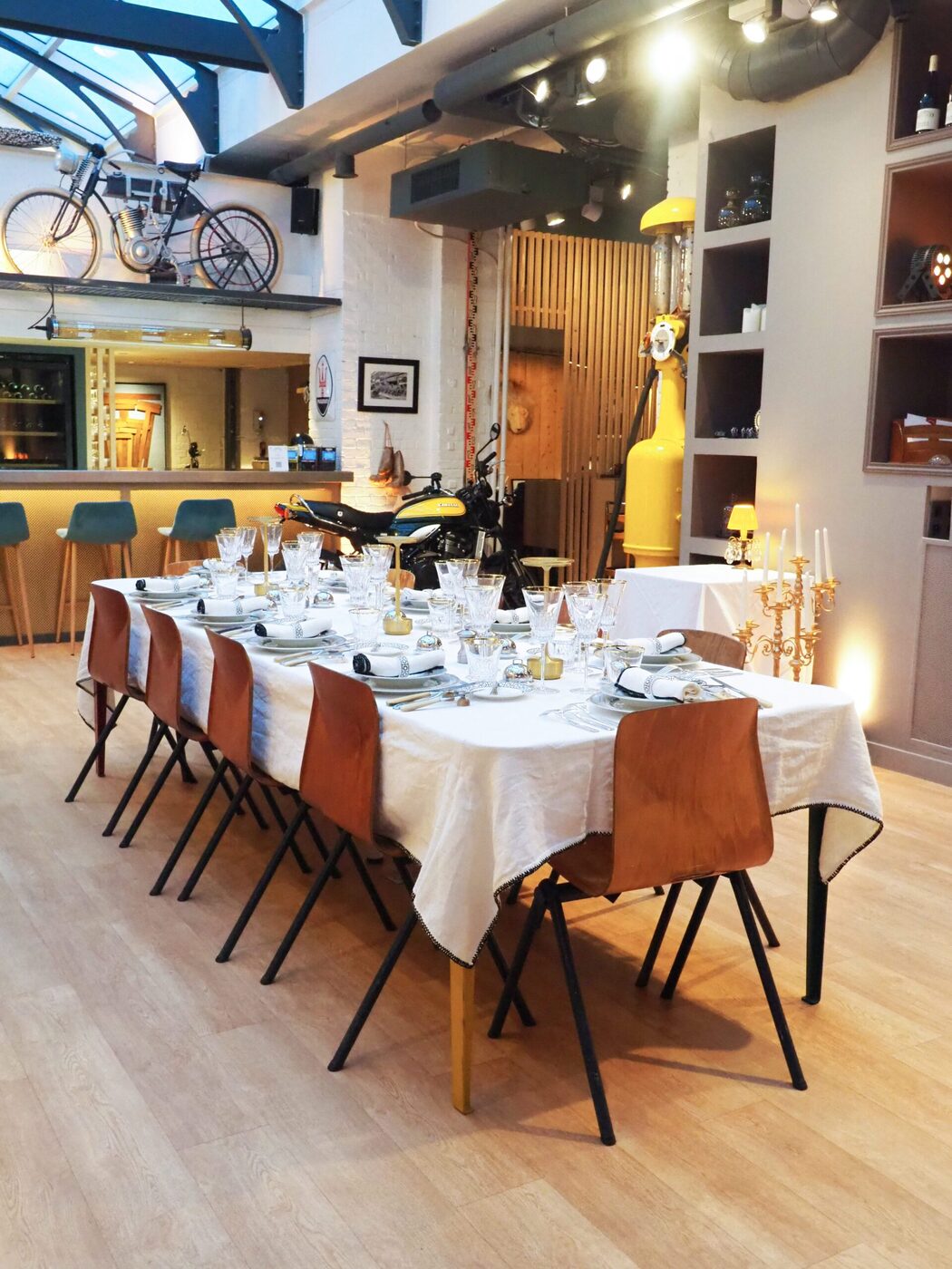 Grande table dressée de blanc pour un dîner assis, candélabres et verres de cristal