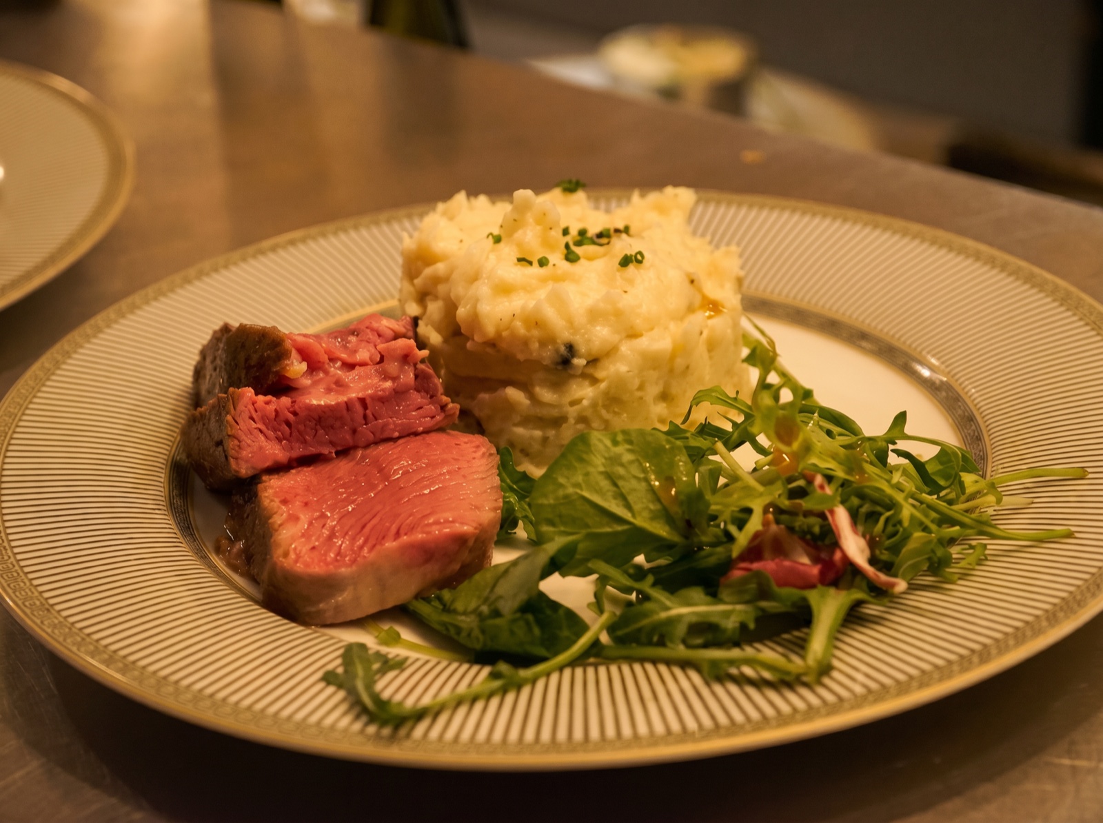 Plat gastronomique dressé : bœuf rosé, écrasé de pommes de terre, salicorne