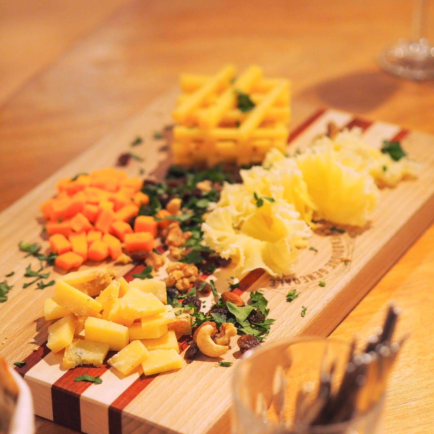 Planche de fromages AOP dressée sur le plateau siglé La Fabrique Générale · fruits secs, noix et herbes fraîches