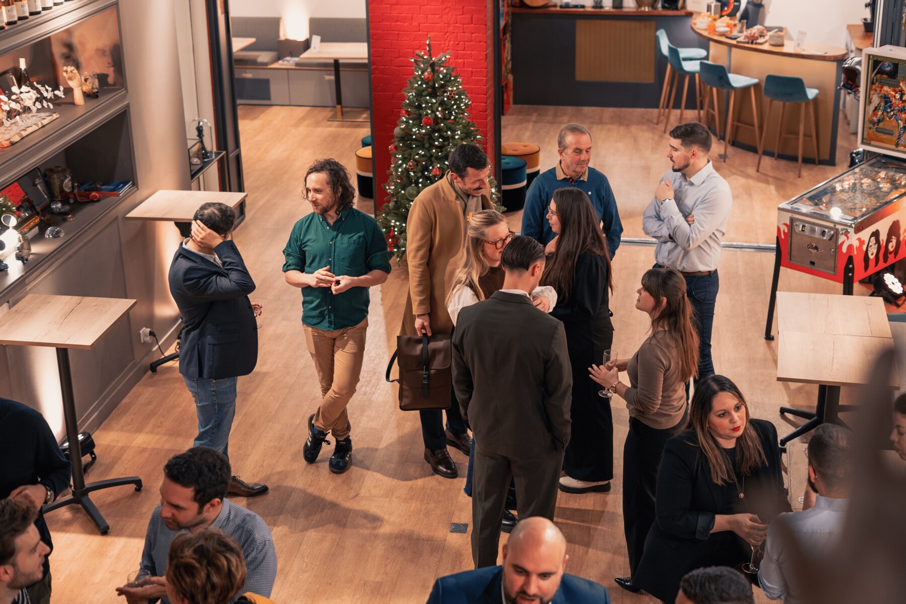Soirée d'entreprise privatisée à La Fabrique Générale · vue plongeante sur les invités en discussion, sapin de Noël, flipper et mange-debout