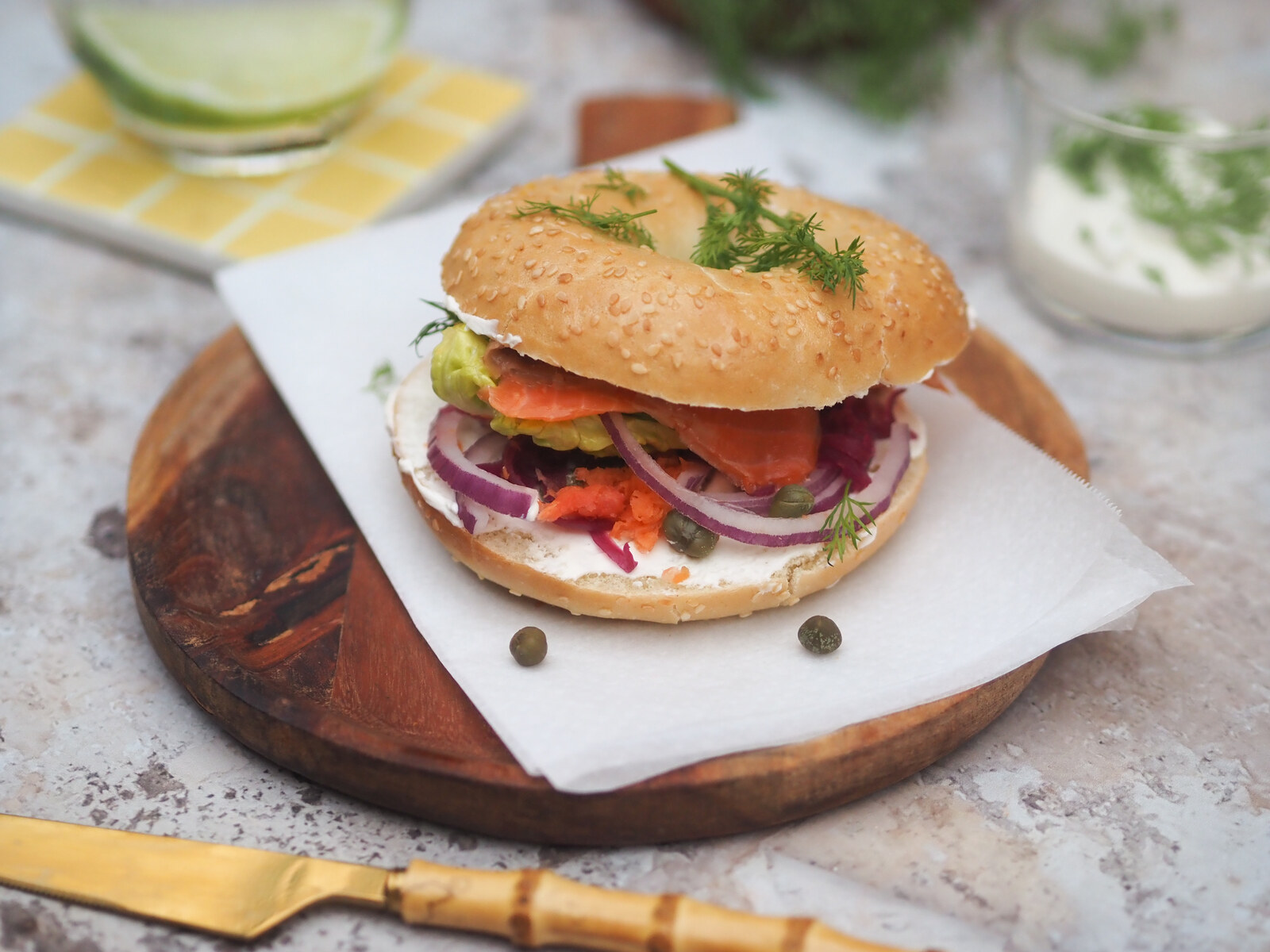 Bagel maison au saumon fumé, cream cheese, oignon rouge et aneth, dressé sur planche à La Fabrique Générale
