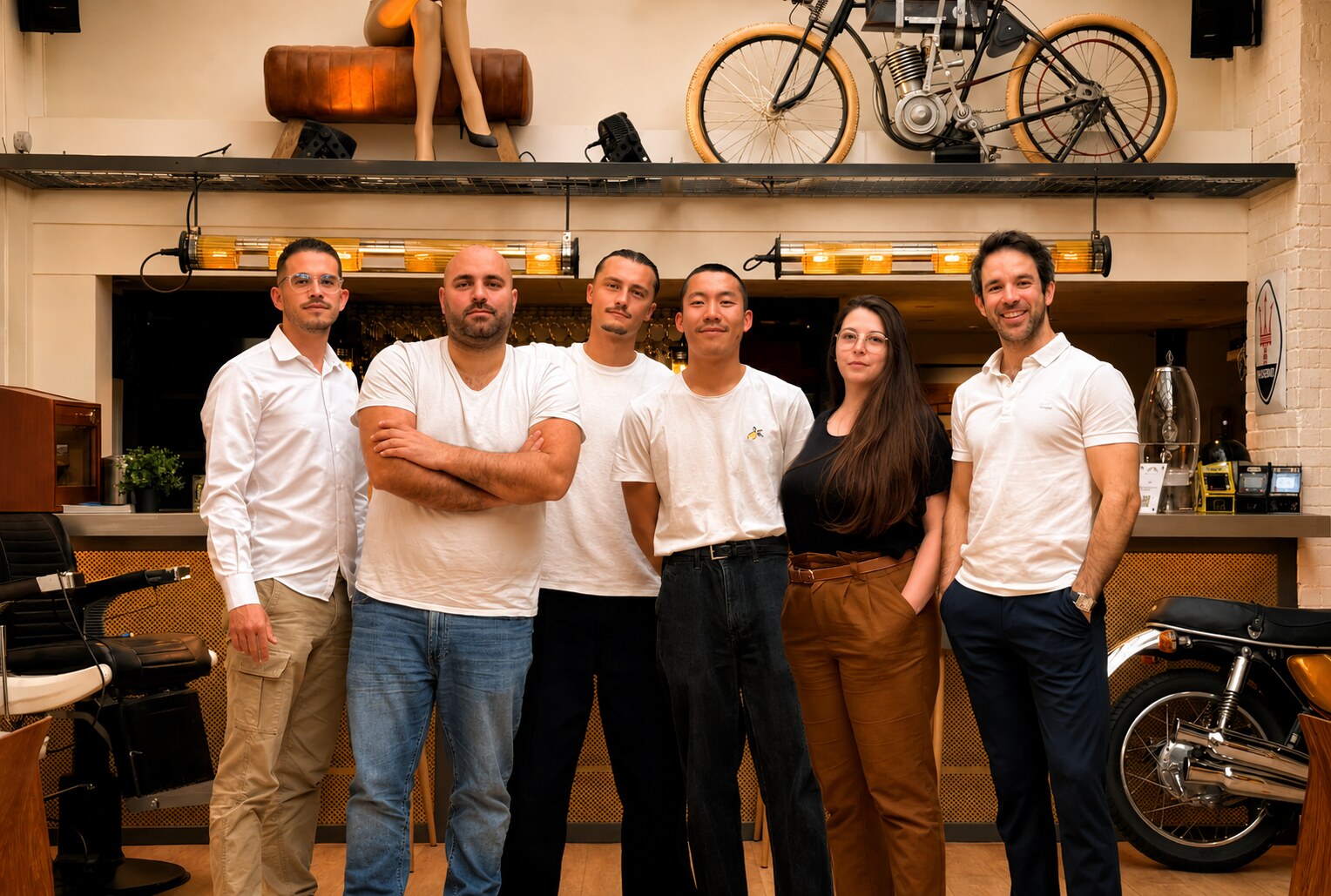 L'équipe permanente de La Fabrique Générale, Julien, Olivier et leurs collaborateurs sous la verrière, devant le bar et les motos d'époque