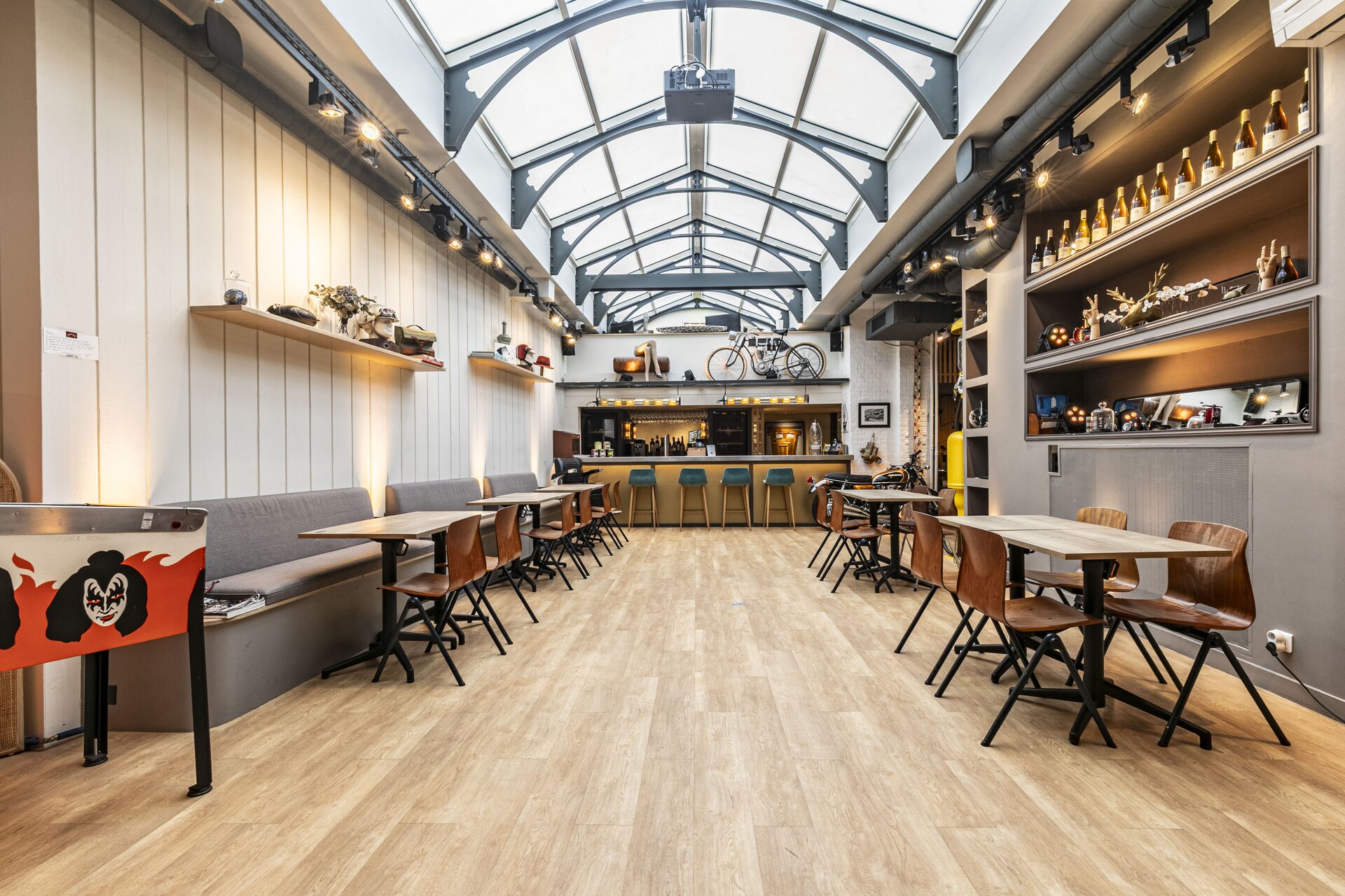 La verrière aujourd'hui · tablées et mange-debout sous la charpente métallique restaurée, bar en fond